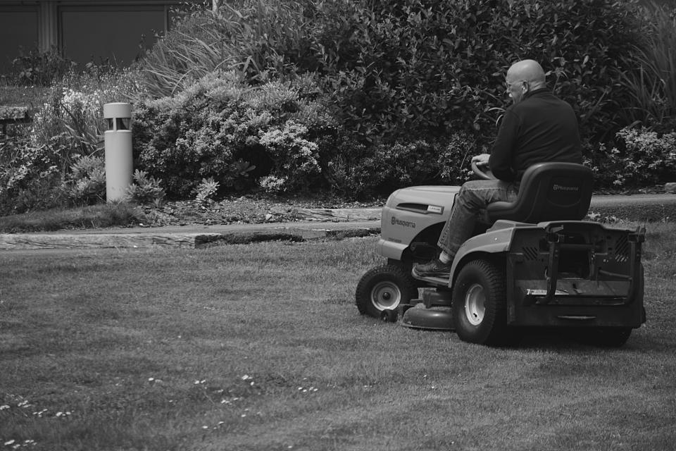 Person mowing a lawn on a riding mower